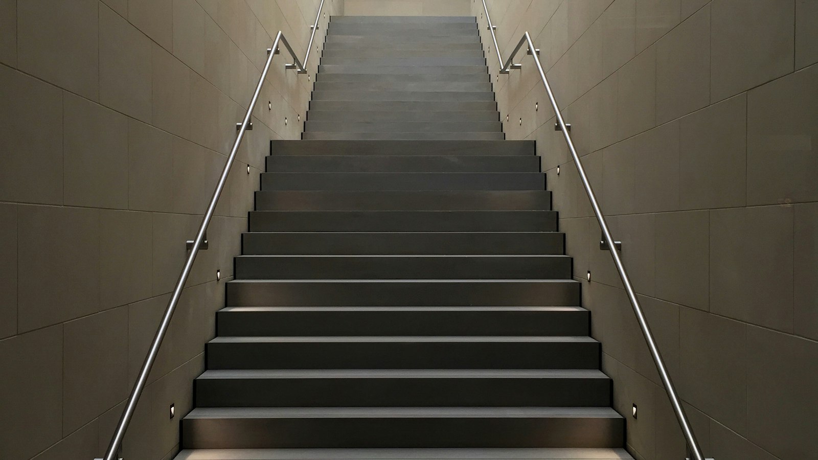 Rote Wendeltreppe an einem minimalistischen Gebäude vor blauem Himmel